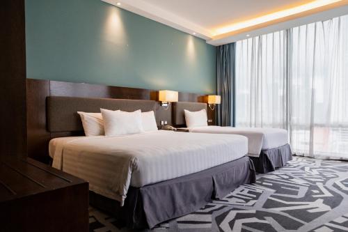 a hotel room with two beds and a large window at WP Hotel in Kuala Lumpur