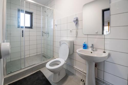 a white bathroom with a toilet and a sink at Tiny Village in Tîrgu Secuiesc