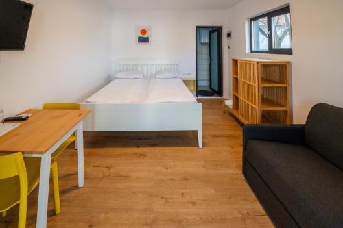 a room with a bed and a table and a couch at Tiny Village in Târgu Secuiesc