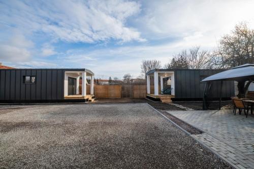 a small black shipping container with a house at Tiny Village in Târgu Secuiesc