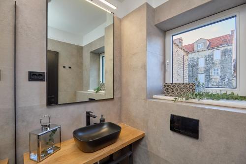a bathroom with a black sink and a window at Hedera Estate, Villa Hedera XVII in Dubrovnik