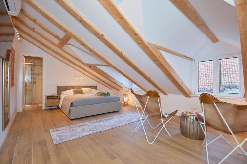 a bedroom with a bed and two chairs at Hedera Estate, Villa Hedera XVII in Dubrovnik