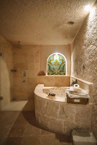 a bathroom with a large stone tub and a shower at Hu of Cappadocia - Special Class in Uchisar