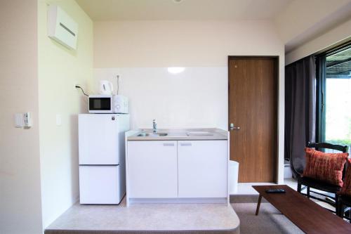 una cucina con un frigorifero bianco e un lavello di Arbor house a Kagoshima