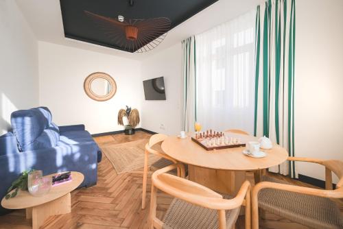 a living room with a table and a blue couch at MADISON Saint Jean de Luz - Handwritten Collection in Saint-Jean-de-Luz