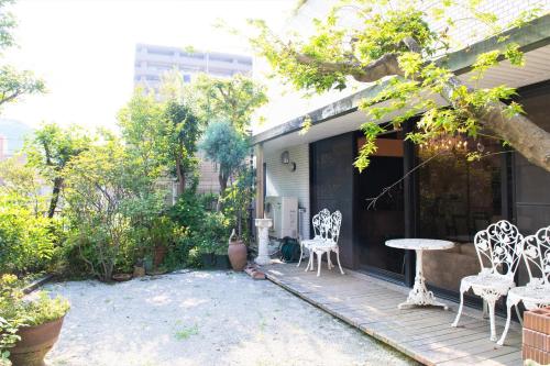 eine Terrasse mit Stühlen und einem Tisch auf einem Haus in der Unterkunft Arbor house in Kagoshima
