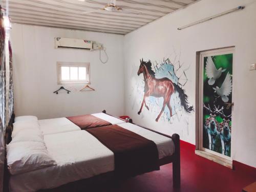 a bedroom with a bed with a painting of a horse on the wall at Achayans Homestay Mararikulam in Mararikulam