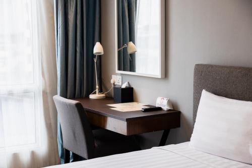 a desk in a hotel room with a bed at WP Hotel in Kuala Lumpur