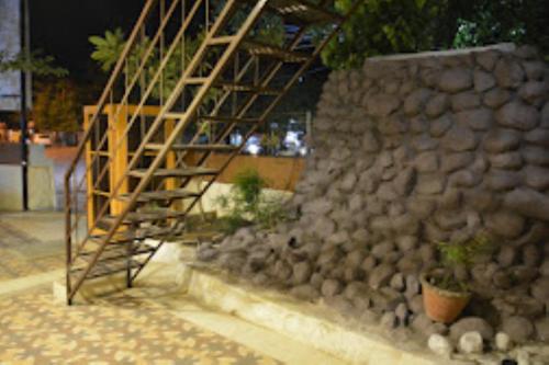 een houten trap naast een stenen muur bij HOTEL SAIPRASAD LODGE Solapur in Solapur