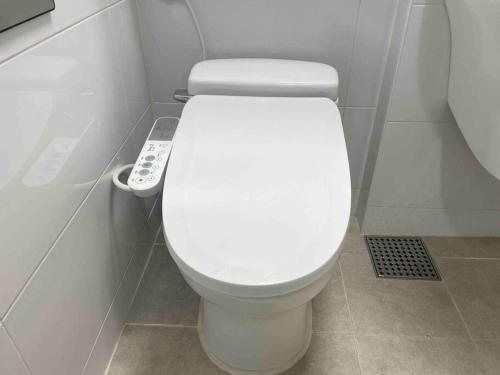 a white toilet in a bathroom with a remote control at NEST Myeongdong Residence high-rise floor #Namsan #Hanok village #Gyeongbok palace #Euljiro in Seoul