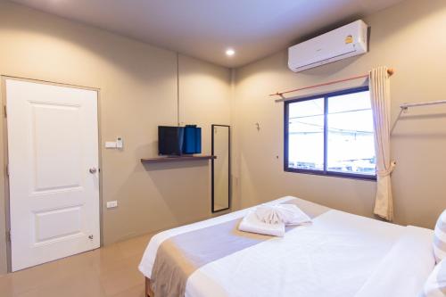 a bedroom with a white bed and a window at Baan Tah On The Sea in Bang Sare