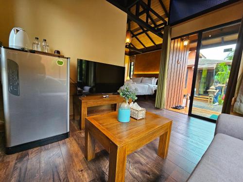 a living room with a refrigerator and a table at R1 Resort Rajapruek Chiangmai in Chiang Mai