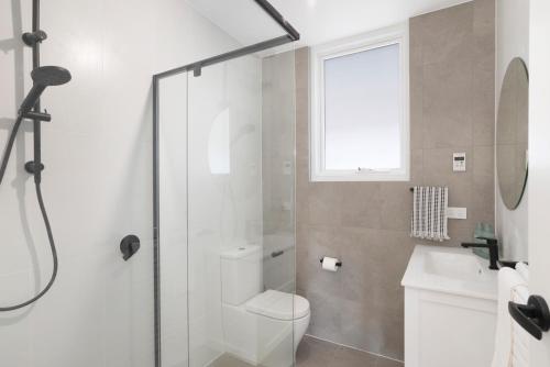 a bathroom with a shower and a toilet and a sink at The Elements l Earth l 4 Stunning Apartments each with Private Outdoor Dining l Walk to the Beach l Pet Family and Event Friendly l Wifi l Netflix l Outdoor Shower l Communal BBQ Pavilion and Lawn Area l in Christies Beach