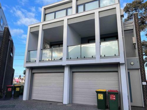 MulgraveNew and Sophisticated Home的一座建筑,设有两扇车库门和四扇窗户