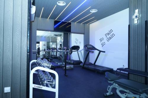 a gym with treadmills and machines in a room at Nova Park Hotel in Sharjah