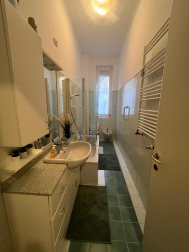 uma casa de banho branca com um lavatório e um WC em Porta Venezia Apartament em Milão