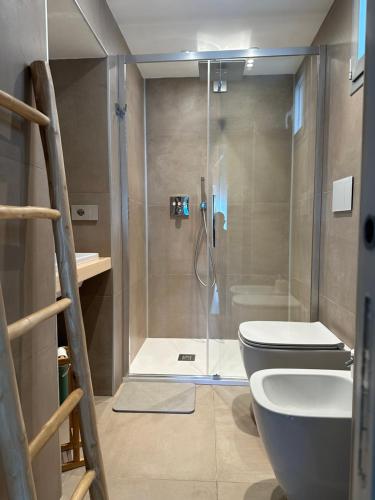 a bathroom with a shower with a toilet and a sink at MP Luxury room in Budoni