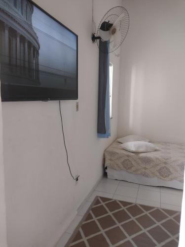 Habitación con TV de pantalla plana y ventilador. en Casa da Mila en Porto Seguro