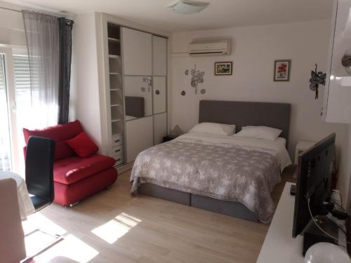 a bedroom with a bed and a red chair at Studio apt. Downtown in Split