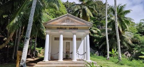 a small building in a park with palm trees at La Belle Tortue in Silhouette Island