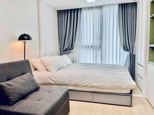 1 dormitorio con cama, sofá y ventana en NEST Myeongdong Residence high floor #Namsan #Hanok village #Gyeongbok palace #Euljiro en Seúl