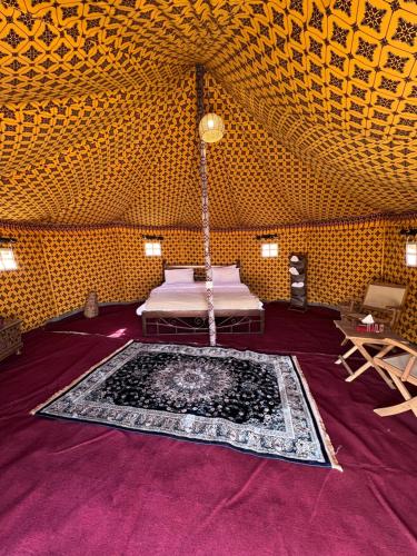 a room with a bed and a rug on the floor at Desert waves camp in Bidiyah