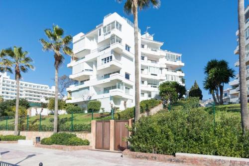 a large white apartment building with palm trees at SEA VIEW & BEACH ACCESS - Center - Parking in Marbella