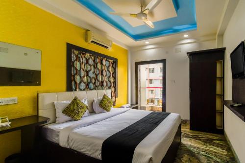 ein Schlafzimmer mit einem großen Bett mit gelben Wänden in der Unterkunft Puja Residency in Thākurdwari