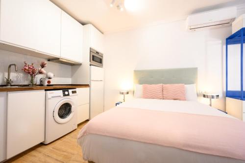 a white bedroom with a bed and a washing machine at El Yate in front of the sea by 10ToSea in Fuengirola