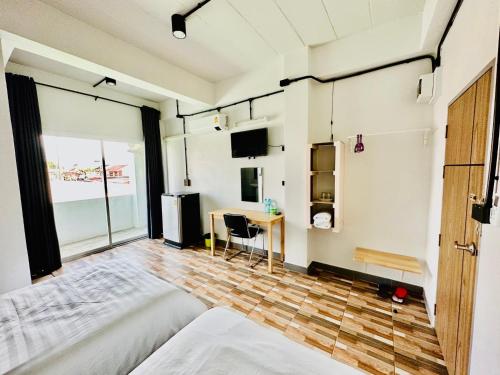 Schlafzimmer mit einem Bett und einem Schreibtisch mit einem Fenster in der Unterkunft BureeSateng Hotel in Yala