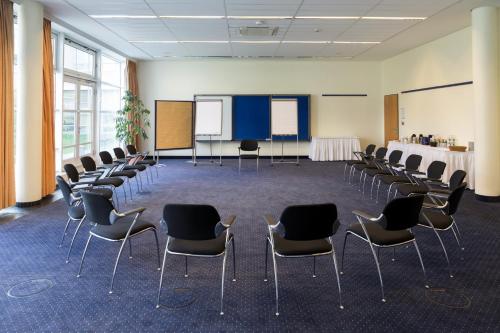 a room with chairs and a table and a screen at Seminaris SeeHotel Potsdam in Potsdam