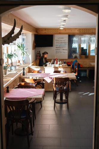 a restaurant with tables and a person in the kitchen at Ospizio La Veduta in Bivio