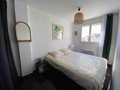une petite chambre avec un lit et une fenêtre dans l'établissement Appart T2 Calme - Centre de Canet - Parking - Clim, à Canet