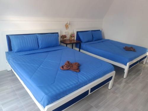two beds with blue sheets in a room at Blue Zone Hostel in Kaôh Rŭng (3)