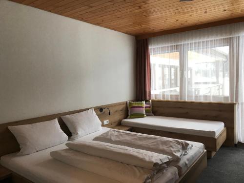 1 Schlafzimmer mit 2 Betten und einem Fenster in der Unterkunft Ferienwohnungen Bailom in Elbigenalp