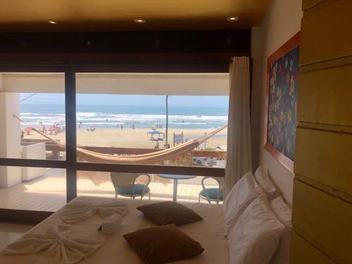 a bedroom with a bed and a view of the beach at Pousada Beira Mar - Suítes Frente ao mar in Torres