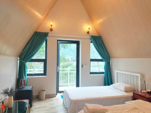 a attic bedroom with two beds and a window at Carambola Bungalow in Phong Nha