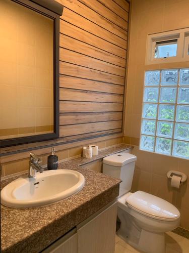 a bathroom with a sink and a toilet and a window at I am pool villa Pattaya no 5 in Ban Nong Phlap