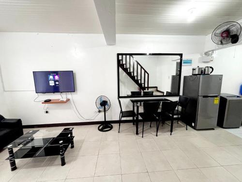 Calapan Transient House L12 في Calapan: غرفة معيشة مع طاولة وتلفزيون