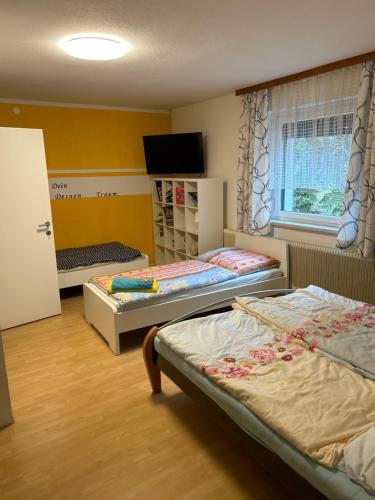 a room with two beds and a tv in it at Heurigenbar in Feldkirchen an der Donau