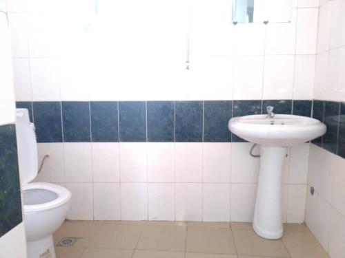 a bathroom with a sink and a toilet at Appart meublé le Dakota in Yaoundé
