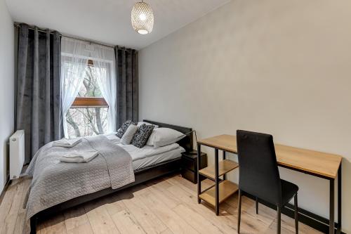 um quarto com uma cama, uma secretária e uma mesa em Aquarius by Grand Apartments em Sopot
