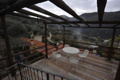 a wooden deck with a table and chairs on it at Agriturismo La Contessa in Finale Ligure