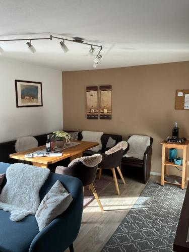 a living room with a couch and a table and chairs at Haus Asslaber in Hochfilzen