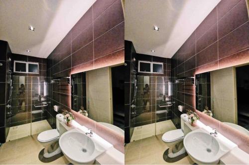 een badkamer met 3 wastafels en een rij toiletten bij Paradise Villa Kempas Utama in Skudai