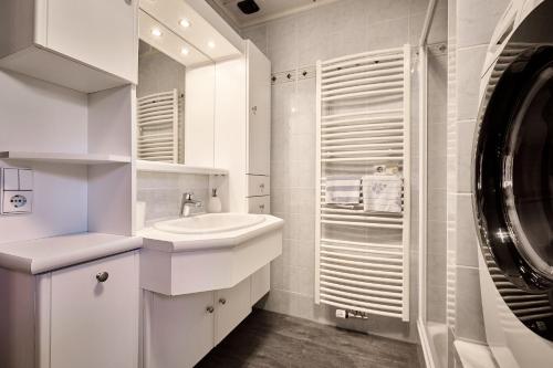 ein weißes Badezimmer mit einem Waschbecken und einer Waschmaschine in der Unterkunft Ferienwohnung Familie Wieser in Altenmarkt im Pongau