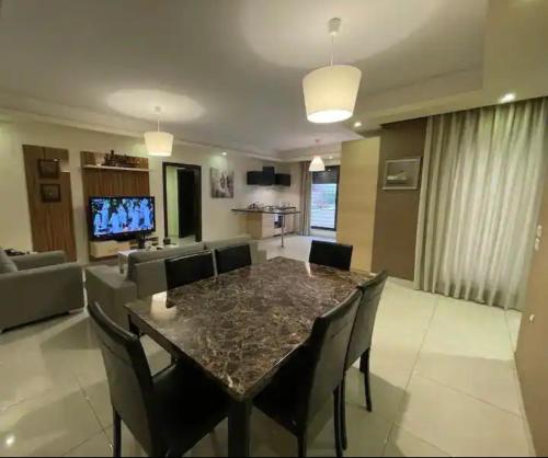 Luxurious cozy apartment في عمّان: غرفة معيشة مع طاولة وكراسي وأريكة