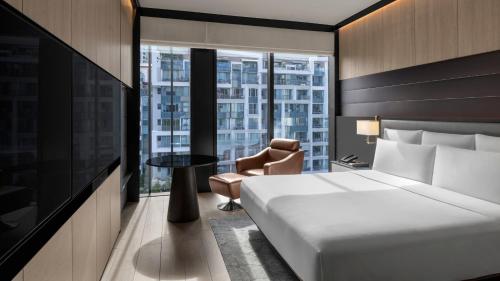 a hotel room with a bed and a chair and a window at InterContinental Singapore Robertson Quay by IHG in Singapore