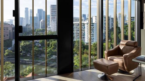 a chair in a room with large windows at InterContinental Singapore Robertson Quay by IHG in Singapore