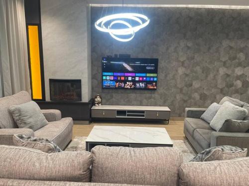 a living room with couches and a flat screen tv at Fabulous Villa In Yerevan. in Yerevan